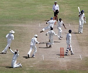 Lankan cricketer Muttiah Muralitharan facing camera jumps after he claimed his 800th Test wicket in the first cricket Test against India. (AP)