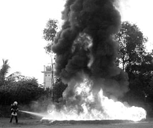 Shop owners removing the remaining articles from the gutted shops. (Right) The Fire and Rescue Services officials extinguishing the fire at SM Street