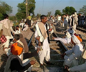 The members of the Gujjar tribe sit on railway tracks to block trains at Peelipura in Bharatpur district of Rajasthan. AP