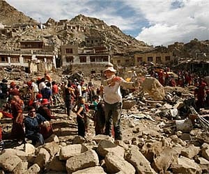 Foreign tourists assist locals in removing debris from a flash flood-affected area of Leh. (AP)