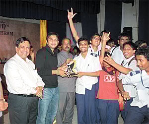 Astounding Victory: The students of P S Senior Secondary receiving the overall trophy from playback singer Karthik| EPS