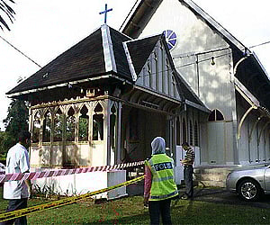 Police officers inspect damage at the All Saints Church in Taiping of Perak state in Malaysia. AP
