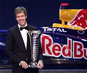 Red Bull Formula One driver Sebastian Vettel of Germany poses with his FIA trophy during the 2011 FIA Gala in Gurgaon Friday.
