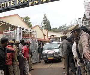 GROUND ZERO: Police hold back the crowd as an ambulance passes out of the Cordite Factory, where the blast occurred in the Nilgiris on Thursday.