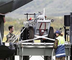 A robot sourced from Perth is unloaded off a Australian Airforce Hercules to aid in the search of the 29 miners trapped at the Greymouth. (AP)
