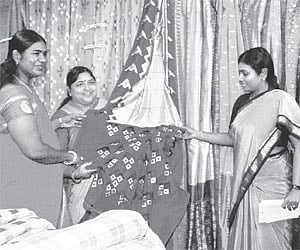 Minister of state for textiles Panabaka Lakshmi along with mayor Banda Karthika Reddy looking at a saree during an exhibition at the inauguration of t