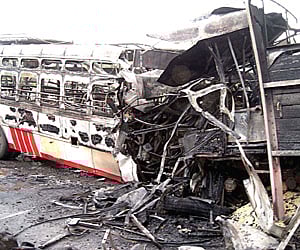 The burnt lorry and government bus at Mallavadi village on Wednesday.