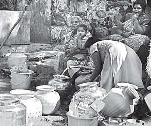 Women queue up at the public tap at Relliveedhi in Visakhapatnam on Monday. | Express Photo