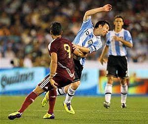 Argentina's Lionel Messi, second left, is blocked by Venezuela's Frank Feltscher during a friendly soccer match in Kolkata, Friday. (AP)