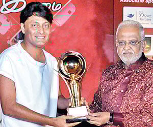Boby Chemmanur receiving the award from singer SP Balasubramaniam at the event.