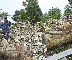 Onlookers gather as rescuers are seen near the wreckage of the Buddha Air plane that crashed on Sunday in Kotdanda.