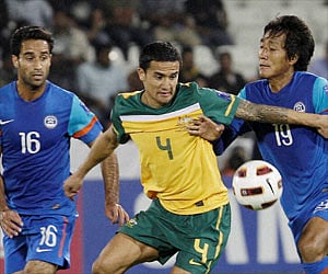Australia's Tim Cahill center fights for ball during the AFC Asian Cup group C soccer match at Al-Sadd Stadium in Doha. PTI