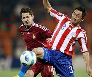 Chased by Venezuela's Cesar Gonzalez, rear, Paraguay's Ivan Piris controls the ball during a Copa America semifinal. AP