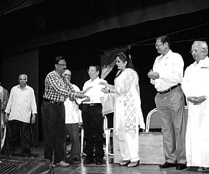 CV Chandramohan receiving Best Director Award from actor Ramya Krishnan