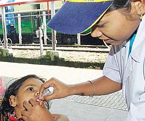 IMMUNISATION DRIVE: A kid being administered polio drop by a health worker at Bhubaneswar Railway Station on Sunday I Express/Shamim.