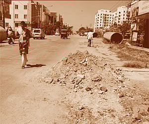 (Left) Sector 1, Main Road in HSR Layout dug up to lay the Cauvery water pipes; (Right) An open drain in the ward