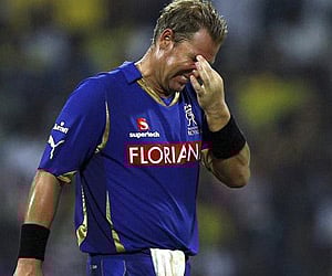 Rajasthan Royals' bowler Shane Warne reacts as Chennai Super Kings' Suresh Raina, right, takes a run during an IPL match in Jaipur. (AP Photo)