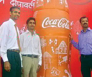 Om Prakash Galav (second from left)  with the 10 feet tall terracotta coke bottle