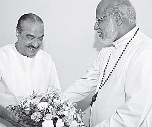 Finance Minister K M Mani presenting a bouquet to Syro-Malabar Church Major Archbishop Mar George Alenchery at St Thomas Mount, the headquarters of th
