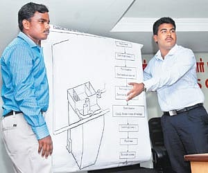 Rizwan and Arunchalam explaining their osmosis tank design.