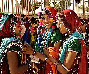 Folk performers in traditional dress queue outside New Delhi’s Jawaharlal Nehru Stadium, the main venue of the Commonwealth Games. AP