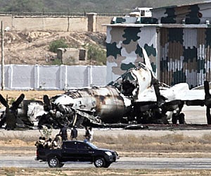 SITTING DUCK: Pakistani troops gather near the P-3C Orion aircraft, which was destroyed in a terrorist attack inside the naval airbase in Karachi, on