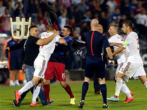 A fight breaks out on the pitch between Serbian fans and Albanian national team players, with from right, Albania's Lorik Cana, Albania's Ansi Agolli, match official, 3rd left Serbia's Nenad Tomovic holding Albanian flag, Albania's Bekim Balaj, and so