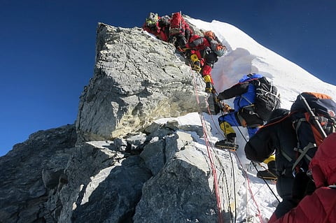 In this image released by mountain guide Adrian Ballinger of Alpenglow Expeditions and taken Saturday, May 18, 2013, climbers navigate the Hillary Step just below the summit of Mount Everest, in the Khumbu region of the Nepal Himalayas. | AP Photo/Alpengl