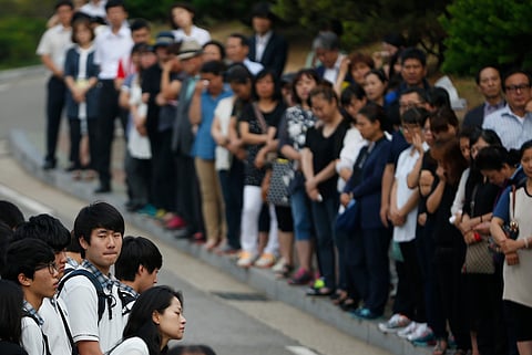 Students who survived the April 16 ferry disaster gather at the main gate as they make their way back to school in Ansan June 25, 2014. | Reuters