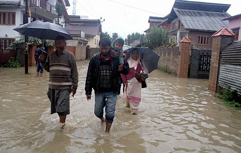 People move towards safer places in the aftermath of a flood due to heavy rains at Mehjjor Nagar in Srinagar on Friday | PTI