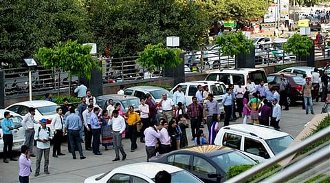People stand after they rushed out of buildings as a strong tremor was felt in New Delhi, India. |AP