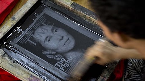 A worker screen-prints a T-shirt featuring a portrait of Myanmar's opposition leader Aung San Suu Kyi in Yangon, Myanmar. 
