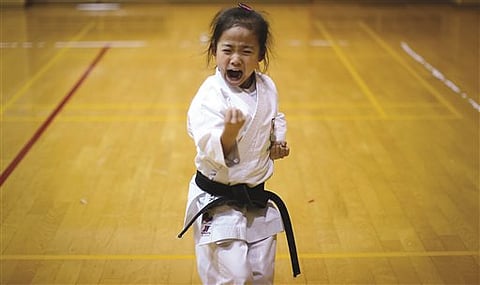 In this Nov. 18, 2015 photo, 9-year-old Mahiro Takano, three-time Japan karate champion in her age group practices in Nagaoka, Niigata prefecture, north of Tokyo. Mahiro stars in singer Sia’s latest music video “Alive,” the just-released single from the s