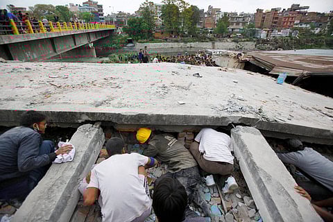 Rescuers look for victims under a building that collapsed after an earthquake in Kathmandu Nepal Saturday April 25 2015. (PTI)