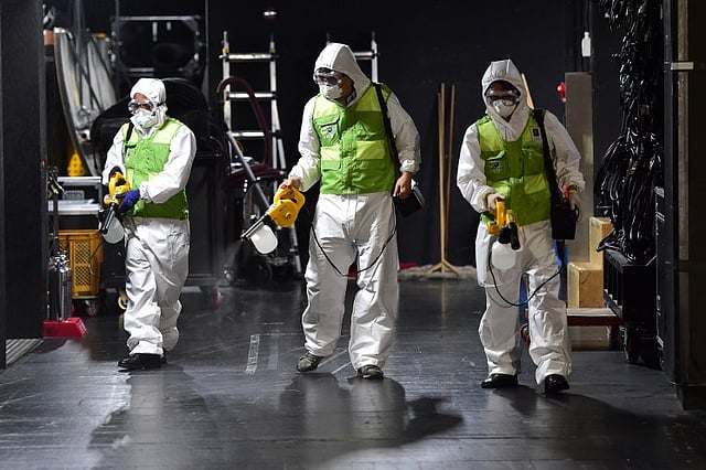 South Korean workers wearing protective gear disinfect a theater at the Sejong Culture Center in Seoul. | AFP