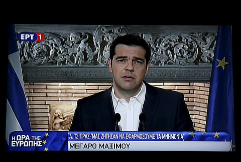 Greek Prime Minister Alexis Tsipras is seen on a television monitor whille addressing the nation early June 27, 2015.| Reuters