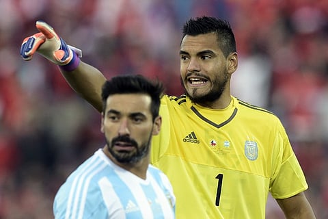 Argentina's goalkeeper Sergio Romero (R) gestures alongside Argentina's forward Ezequiel Lavezzi during their 2015 Copa America football championship final against Chile, in Santiago, Chile. |AFP