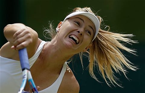 Maria Sharapova of Russia returns a ball to Coco Vandeweghe of the United States during their singles match at the All England Lawn Tennis Championships in Wimbledon, London, Tuesday July 7, 2015. | AP