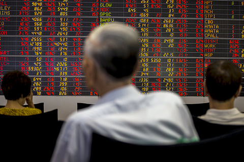 Thai investors sit in front of an electronic board displaying live market data at a stock broker's office in central Bangkok, Thailand. |Reuters