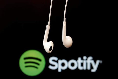 Headphones are seen in front of a logo of online music streaming service Spotify | Reuters