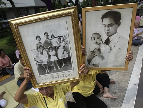 Thais hold portraits of Thai King Bhumibol Adulyadej at Siriraj Hospital where the king is being treated | AP
