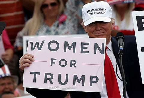 Republican U.S. presidential nominee Donald Trump holds up signs at the end of a campaign rally in Lakeland, Florida | Reuters