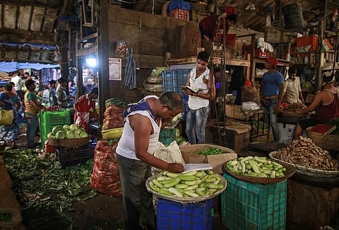 A vendor writes down an order at his stall at a wholesale fruit and vegetable market. (File | Reuters)