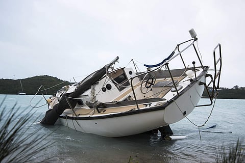A sailboat lays damaged on the shore of Ferry Reach after breaking free from its mooring after the passing of Hurricane Nicole. | AP