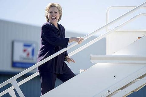Democratic presidential candidate Hillary Clinton laughs as she answers a reporter's question while boarding her campaign plane in White Plains, N.Y. | AP