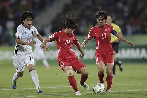 North Korea's Pak Hye Gyong, right, and Ja Un Yong, center, fight for the ball against Japan's Hana Takahashi during the FIFA U-17 women's World Cup final match in Amman Friday, Oct. 21, 2016. | AP