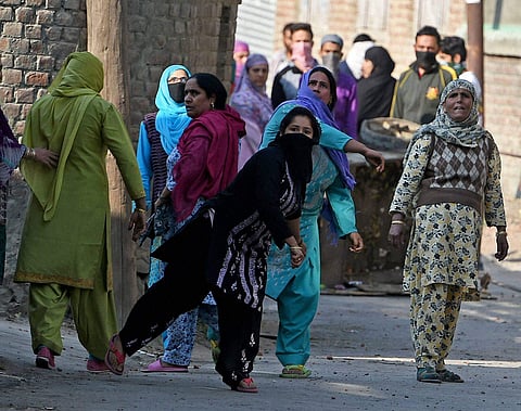 Protesters throw stones at policemen during a protest in Srinagar on Friday.  | PTI