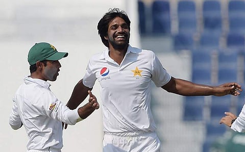 Pakistani bowler Rahat Ali (R) celebrates with teammate Asad Shafiq after taking the wicket of West Indies' batsman Darren Bravo. | AFP