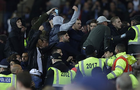 Rival supporters taunt each other and clash with stewards during the English League Cup soccer match between West Ham United and Chelsea. | AP