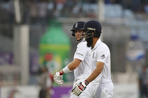 England's Joe Root and teammate Moeen Ali walk back to the pavilion as play stopped due to rain during the first day of the second cricket test match against Bangladesh in Dhaka. (Photo | AP)